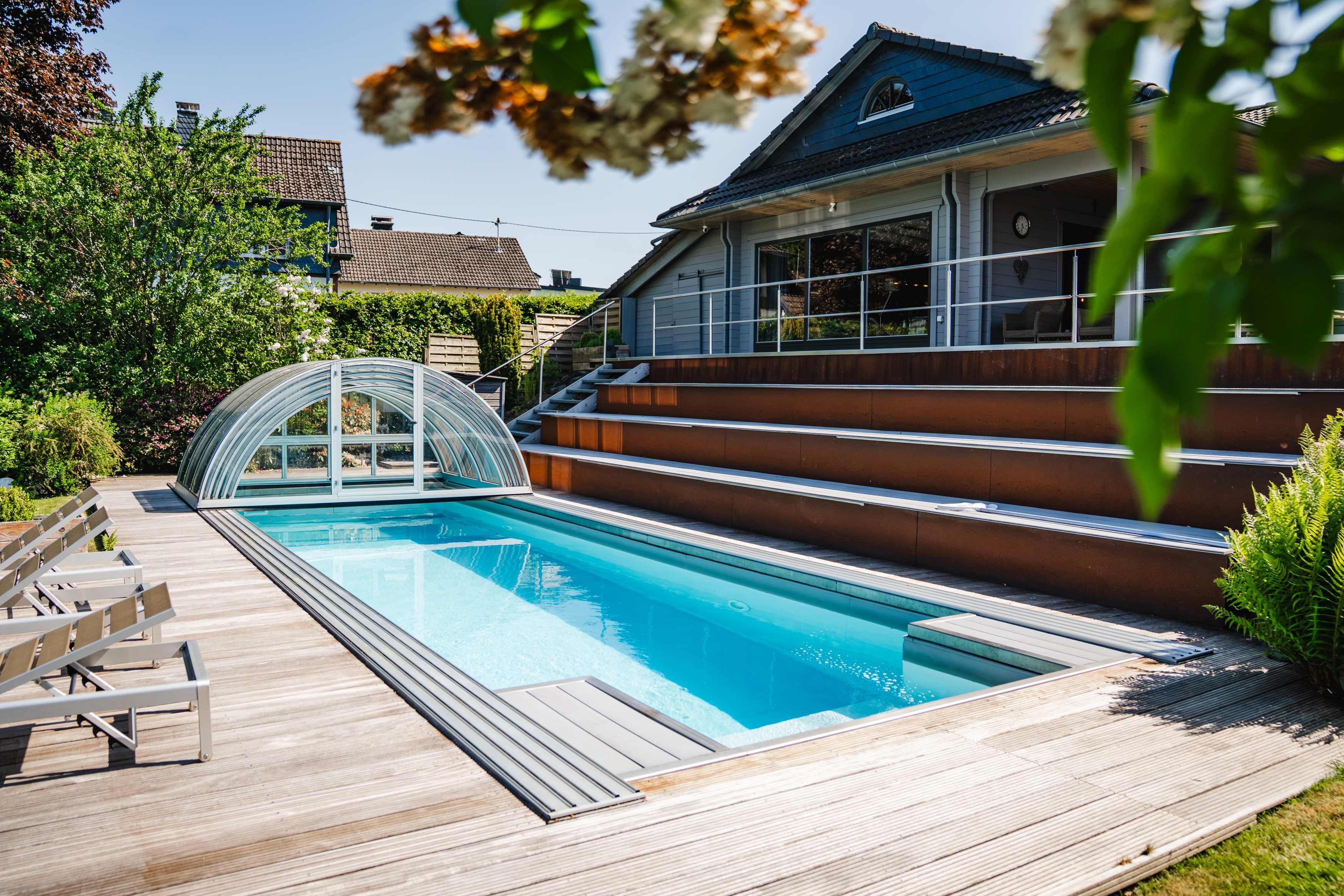 Sonnenterrasse mit Liegen am Pool des Ferienhauses in der Eifel