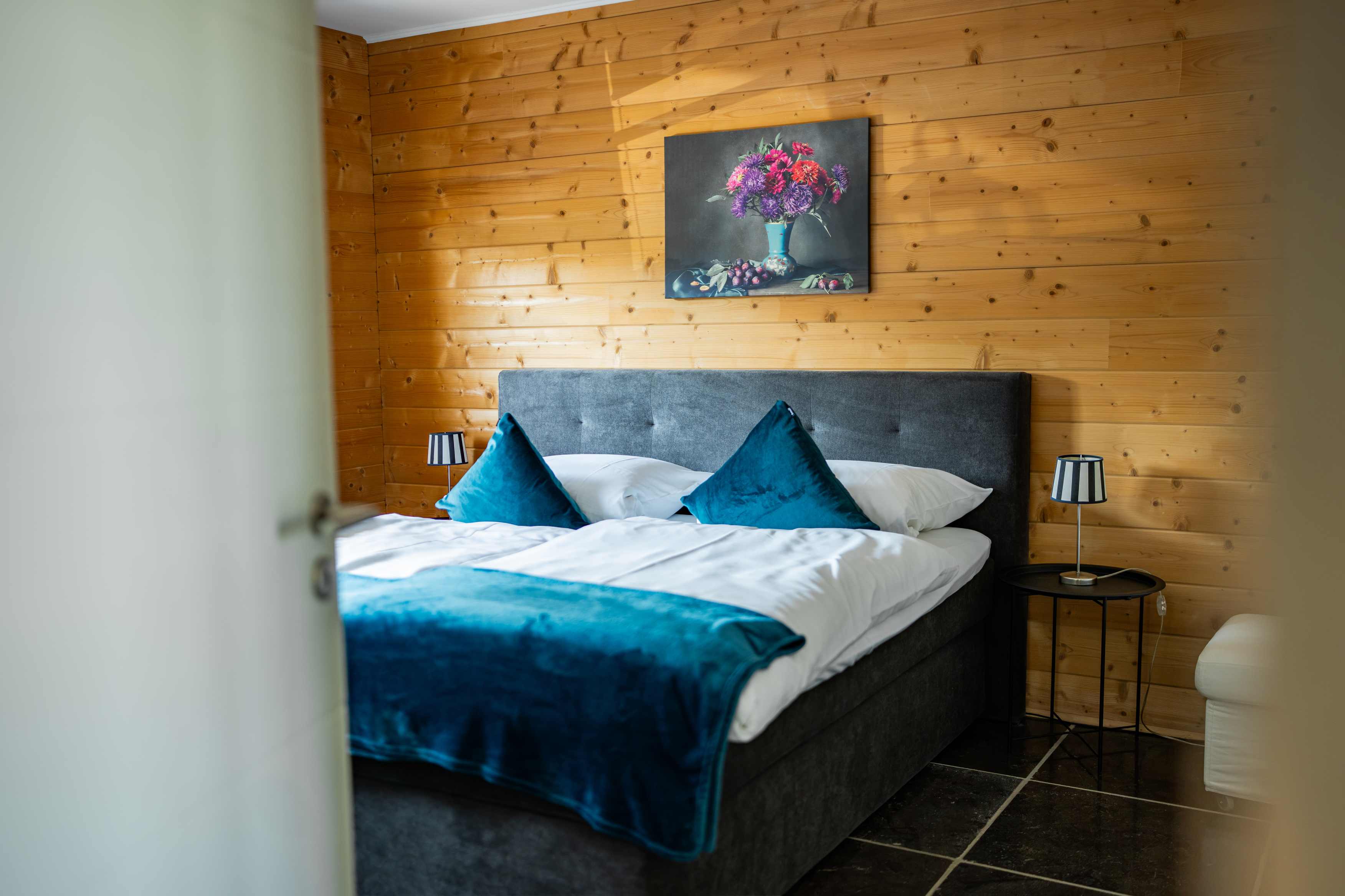 Schlafzimmer mit Holzverkleidung und Blick ins Grüne