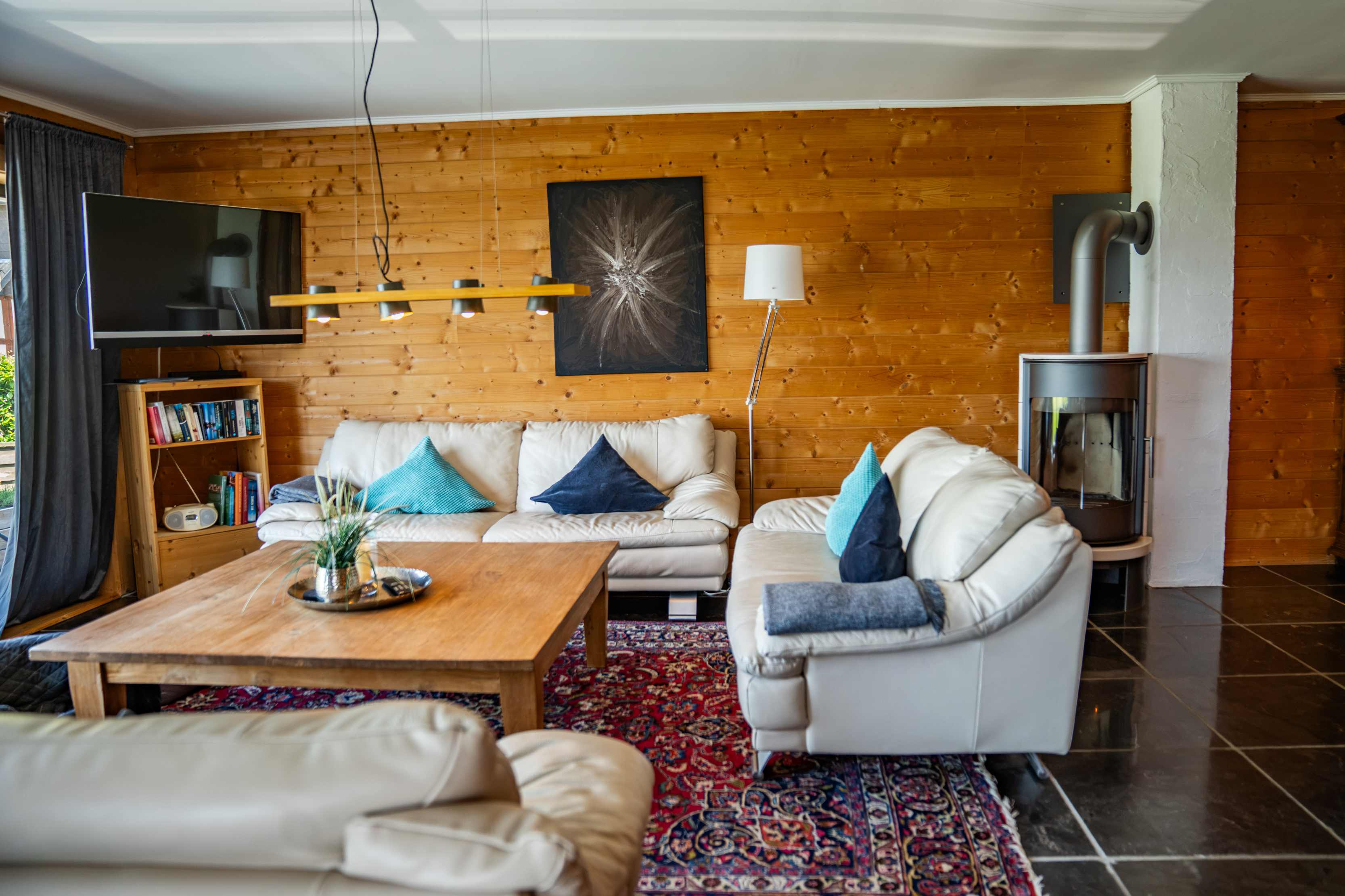 Gemütliche Sofaecke mit Kamin im Ferienhaus in der Eifel